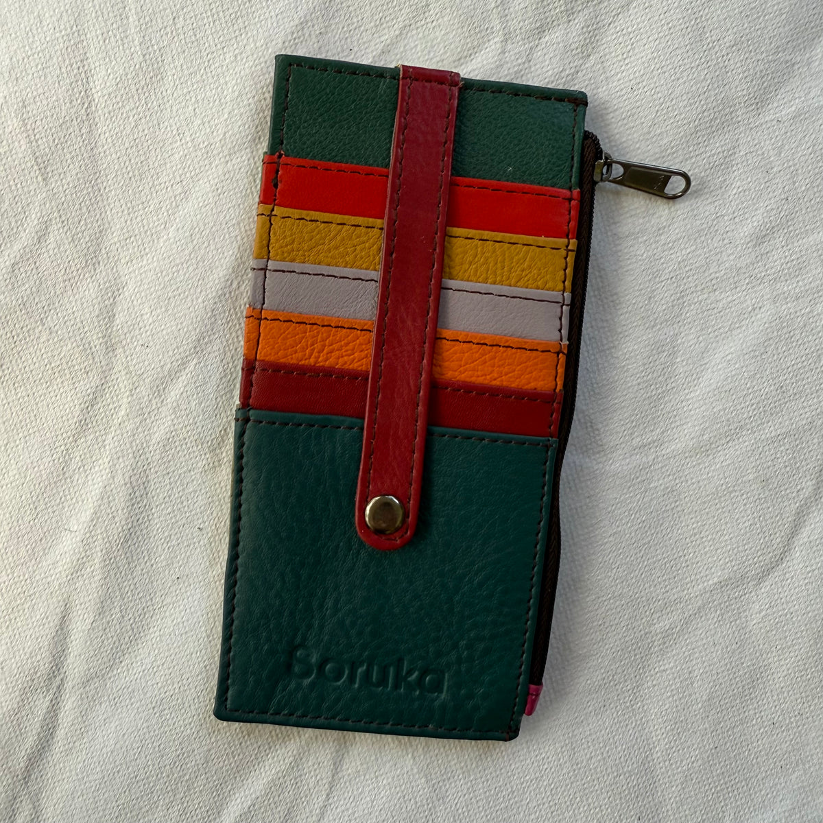 flat wallet with colorful card slots in greens, red, and yellow and a zip pocket along the side
