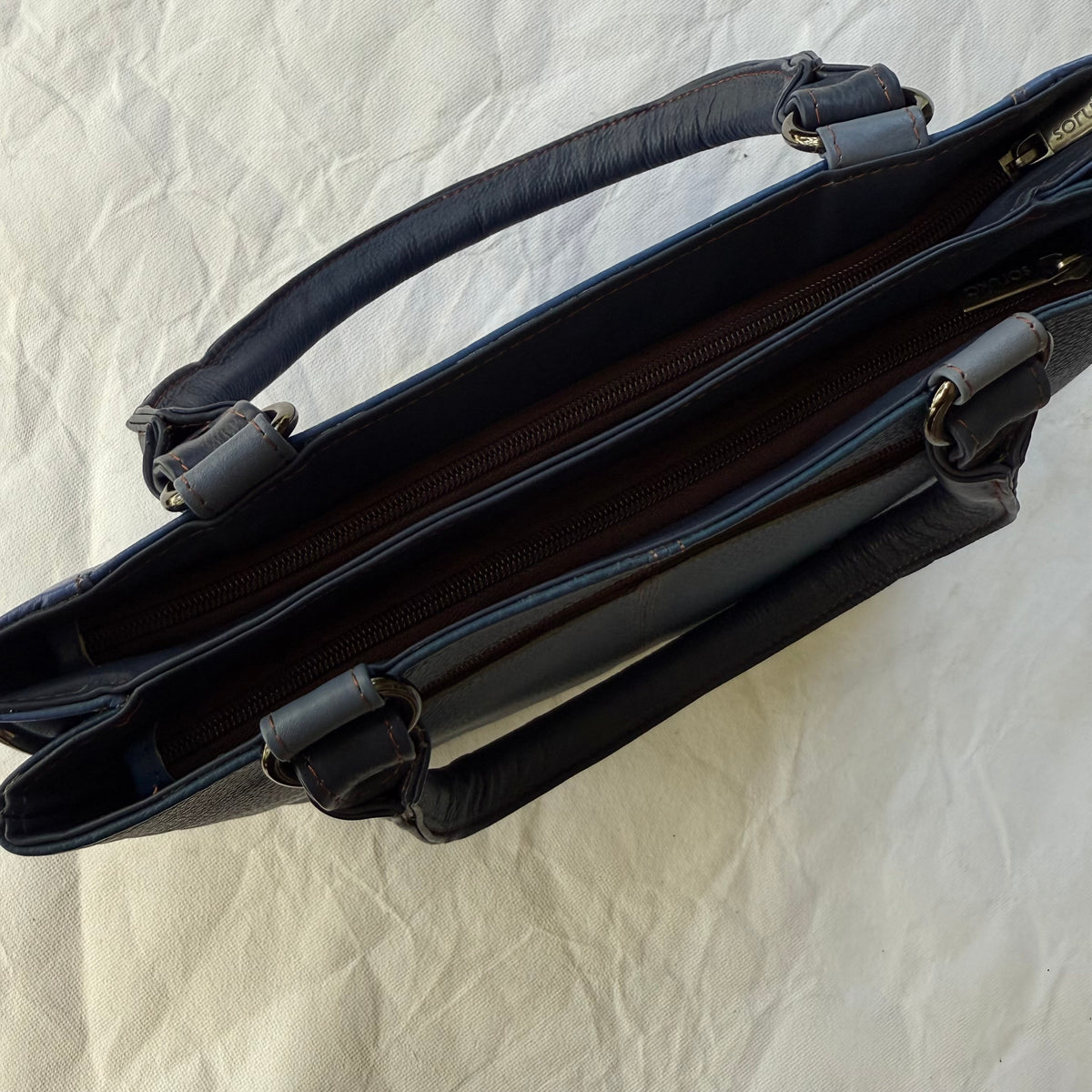 top view of blue handbag with 2 zipped compartments