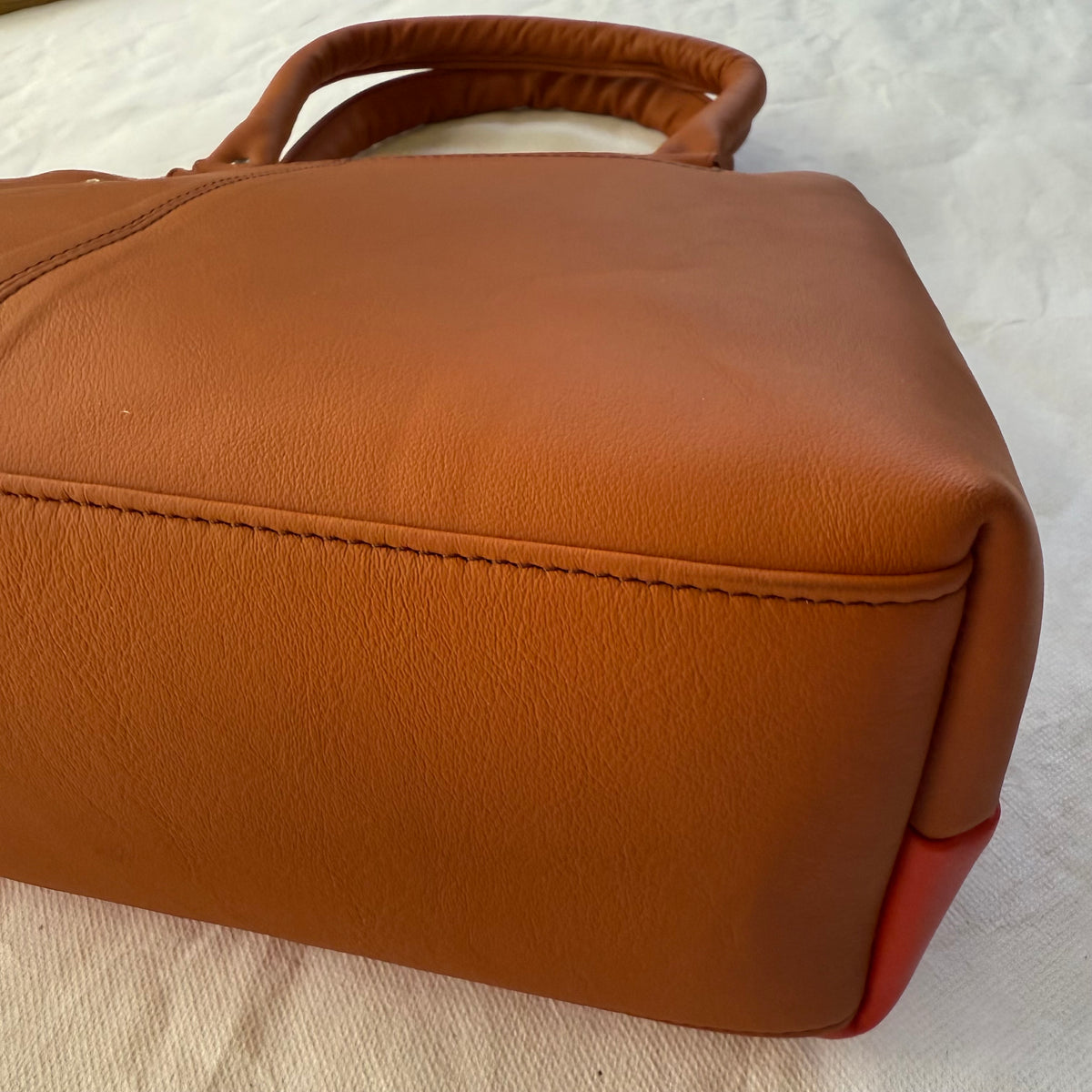 bottom view of orange leathe handbag