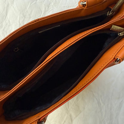 top view of orange leather handbag with 2 unzipped compartments showing interiors
