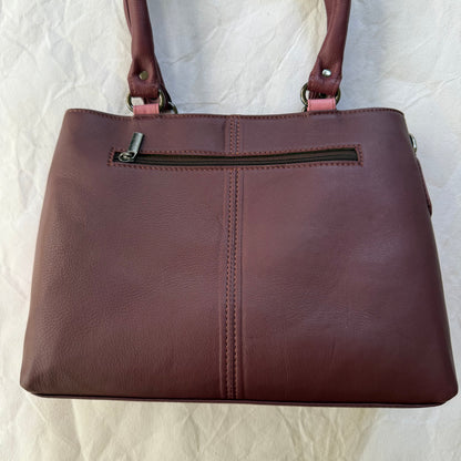 other side of handbag with burgundy leather backing and zipper pocket across the top