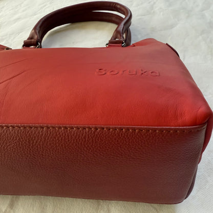 bottom view of red leather handbag with dark red bottom
