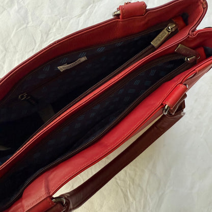 top view of red handbag showing 2 unzipper compartments with dark navy interior