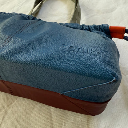 bottom view of burgundy and blue handbag