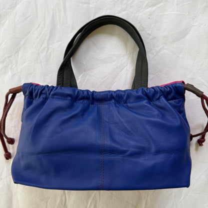 other side of handbag with blue color and grey handles