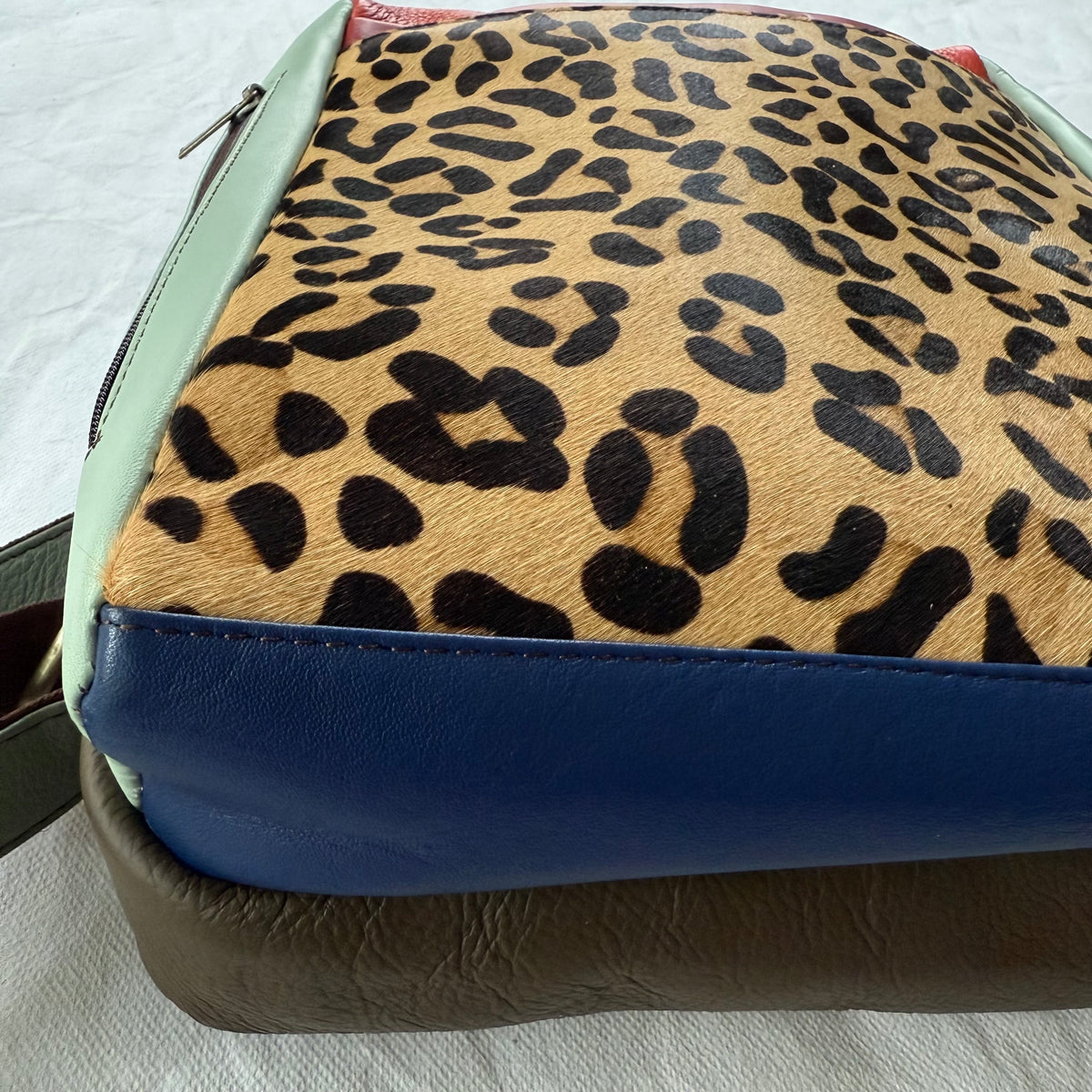 close-up of bottom view of backpack with blue and brown color block sections