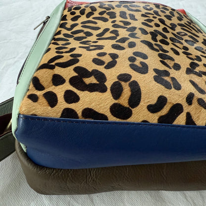 close-up of bottom view of backpack with blue and brown color block sections