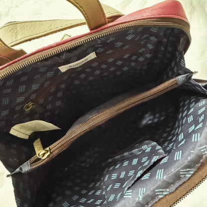 Close-up of the interior of backpack showing a navy patterned lining with zipper pockets