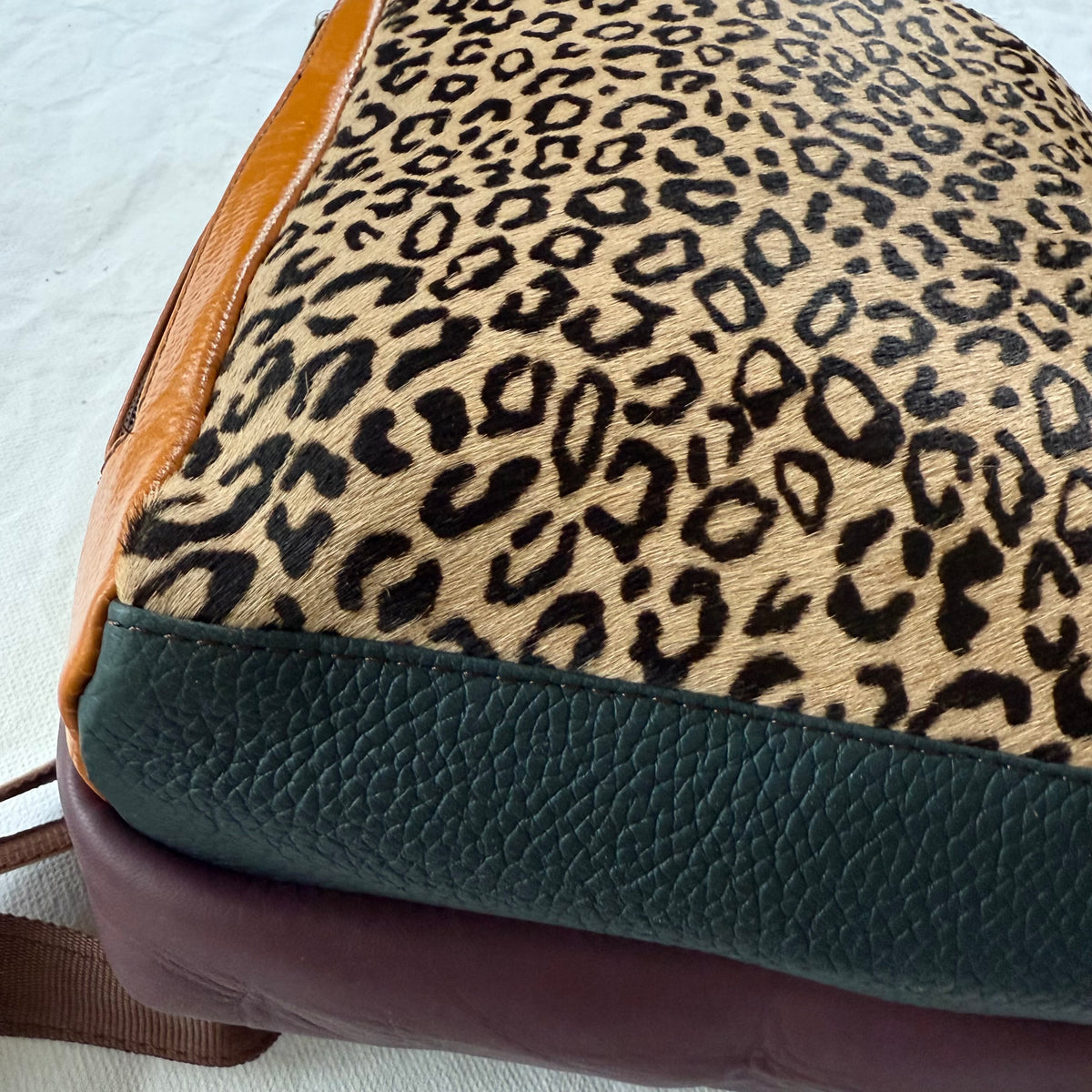 bottom view of backpack showing dark green and maroon color block bottom