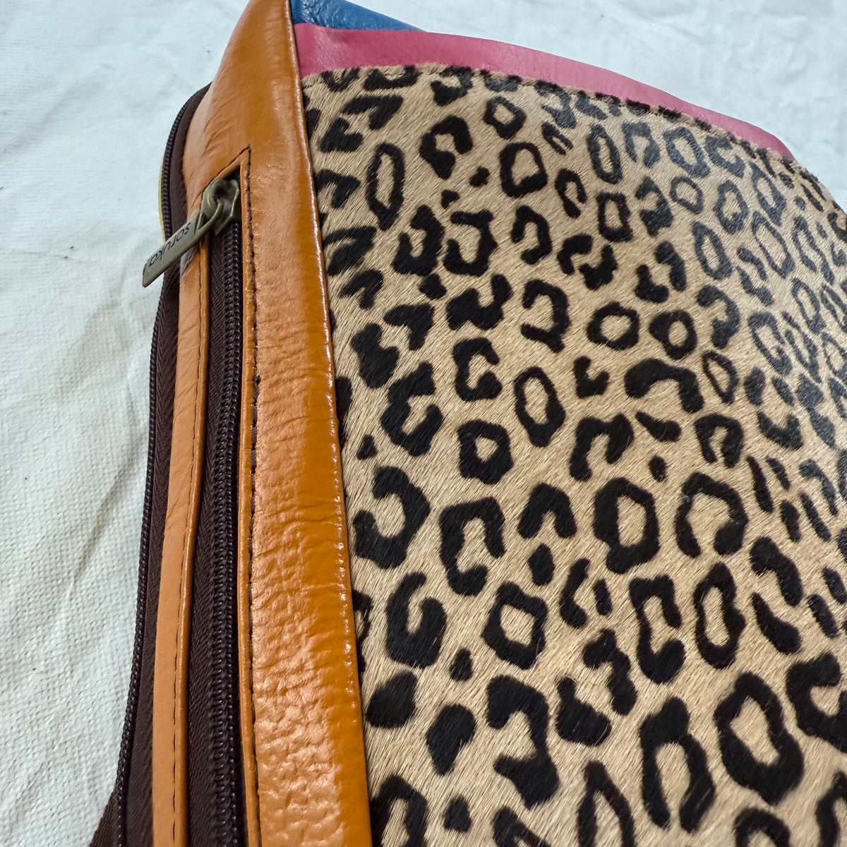 side view of  backpack with orange side panel with zipper in it