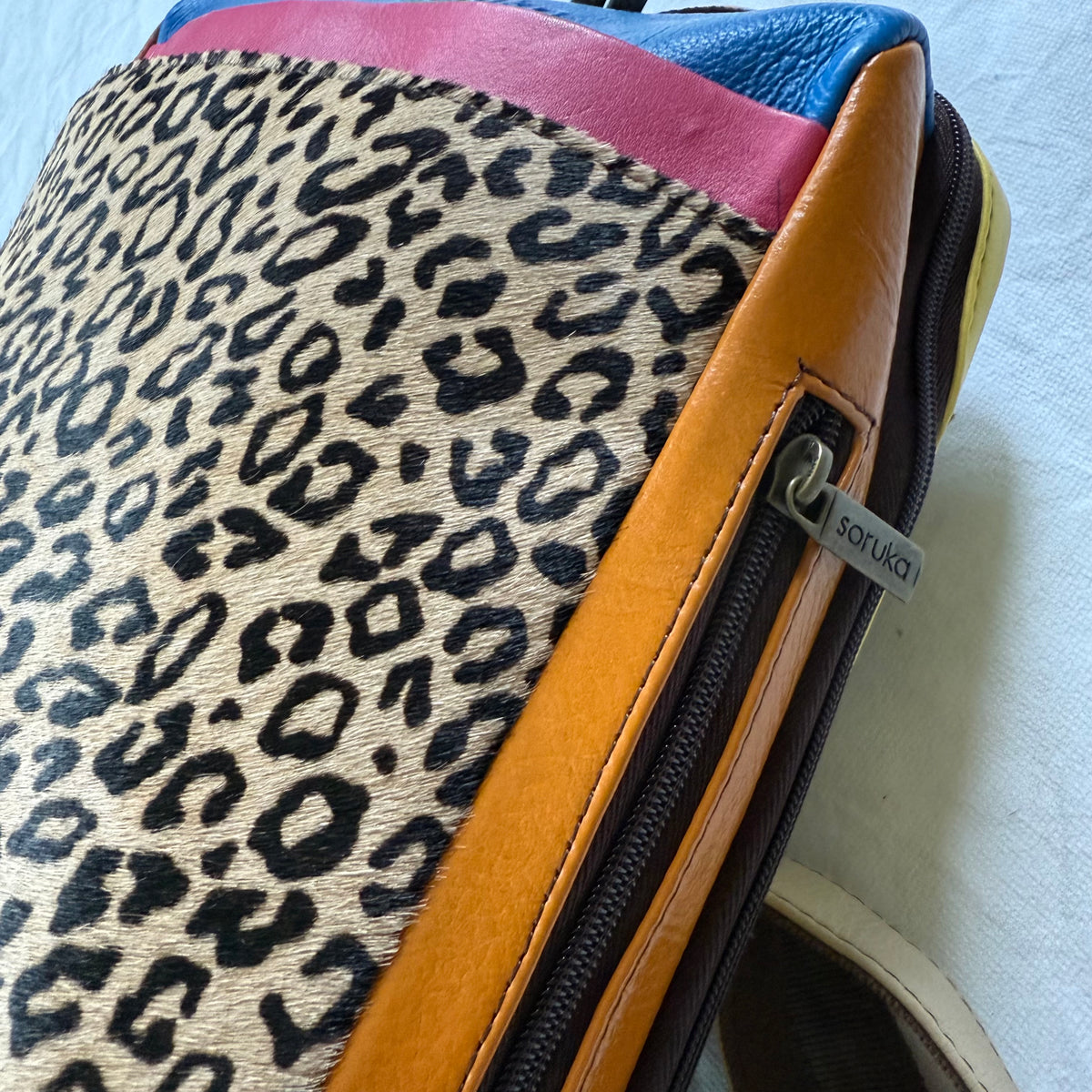 other side of backpack with orange side panel with zipper pocket in it