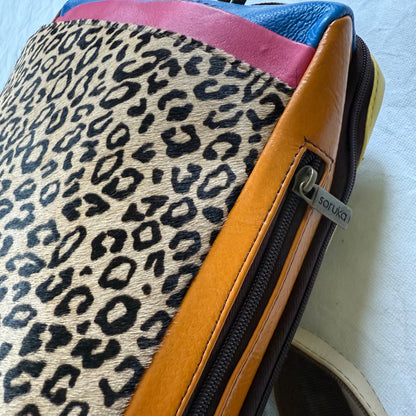other side of backpack with orange side panel with zipper pocket in it