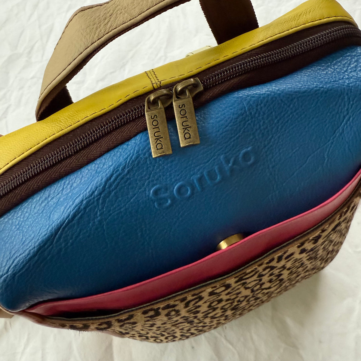 top view of backpack with blue, pink, and yellow color block sections