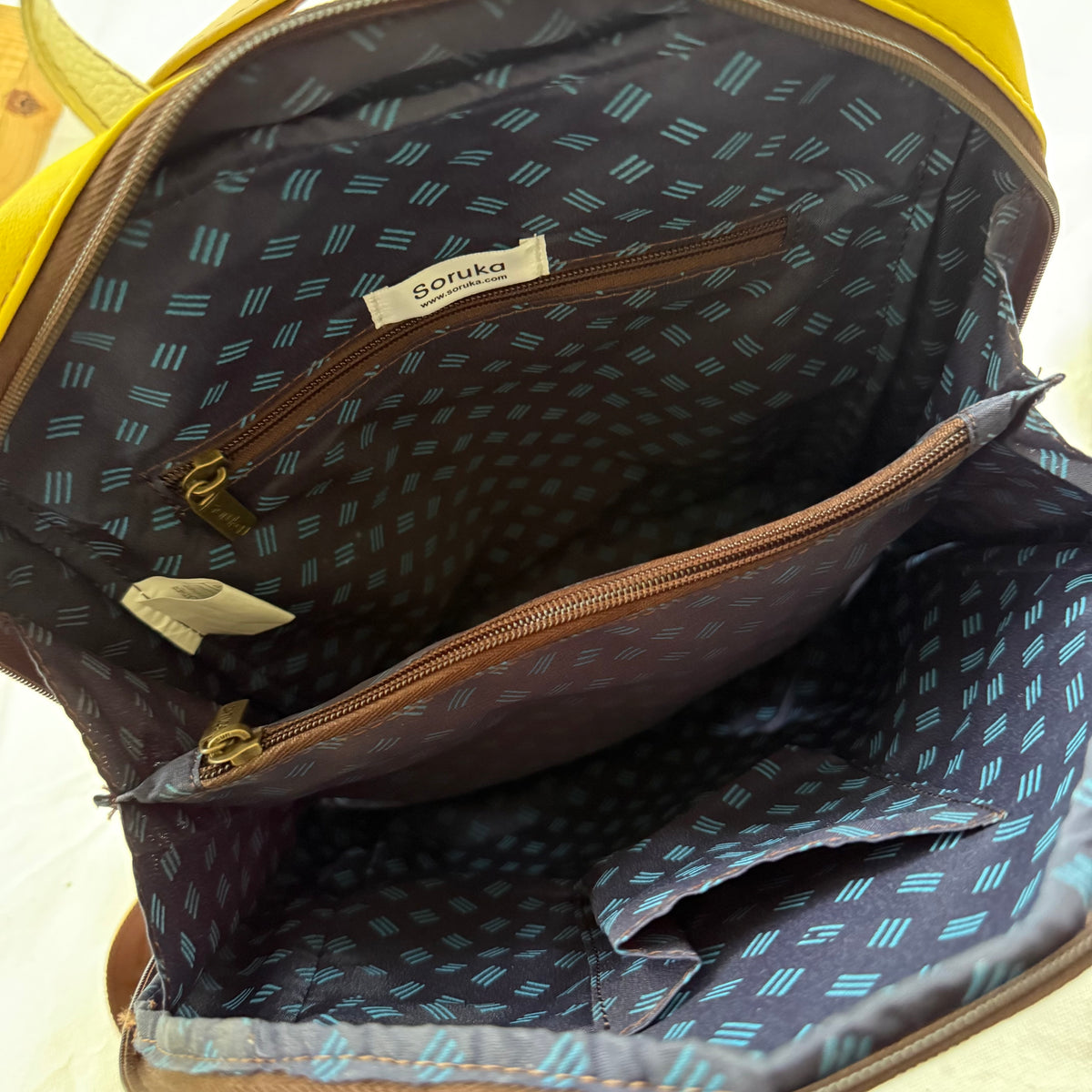 interior view of backpack with navy patterned lining and zippered pockets