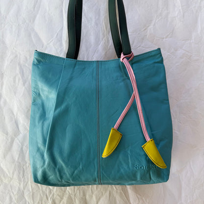 turquoise leather tote bag with tassel and teal shoulder straps