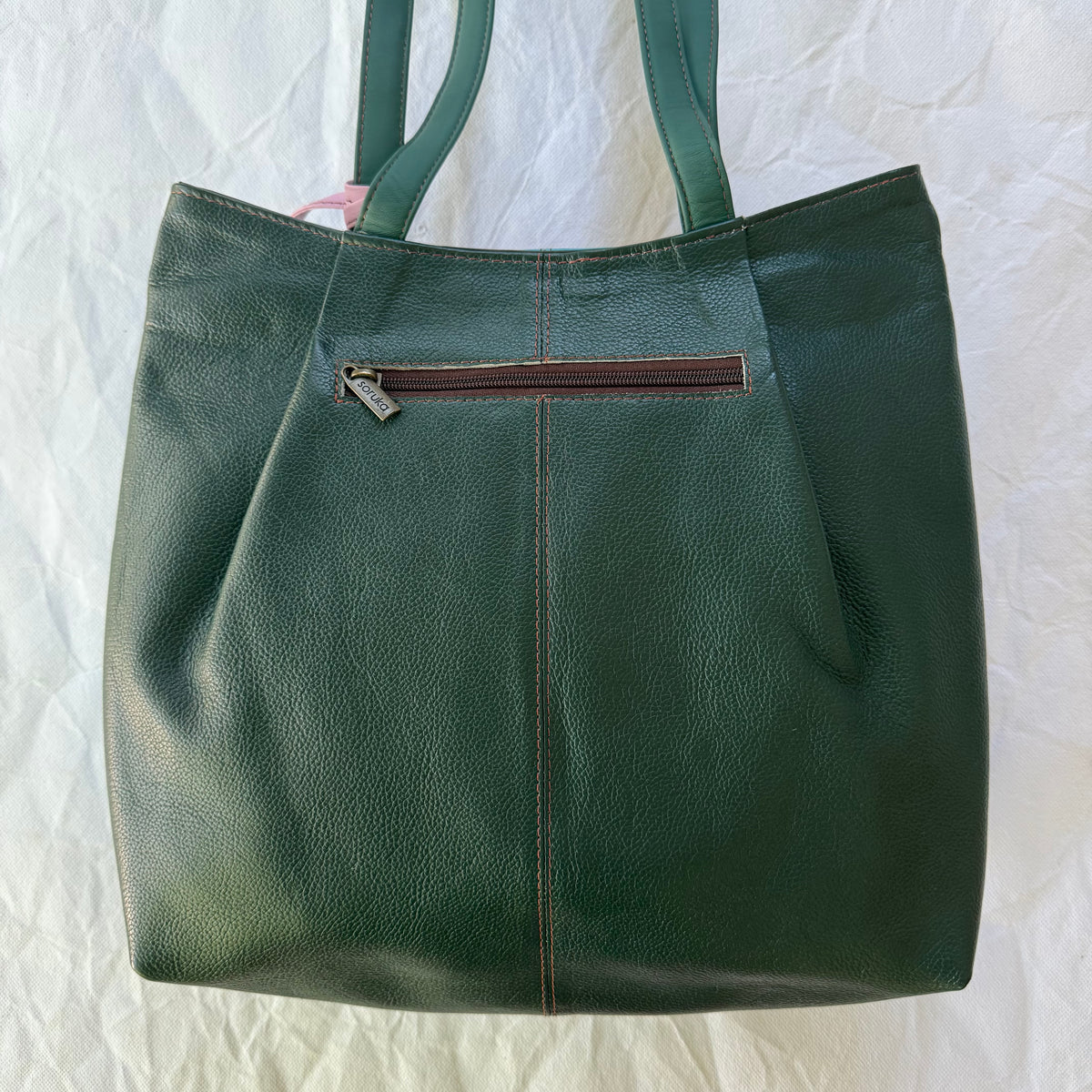 back view of tote showing deep teal backing and zippered pocket