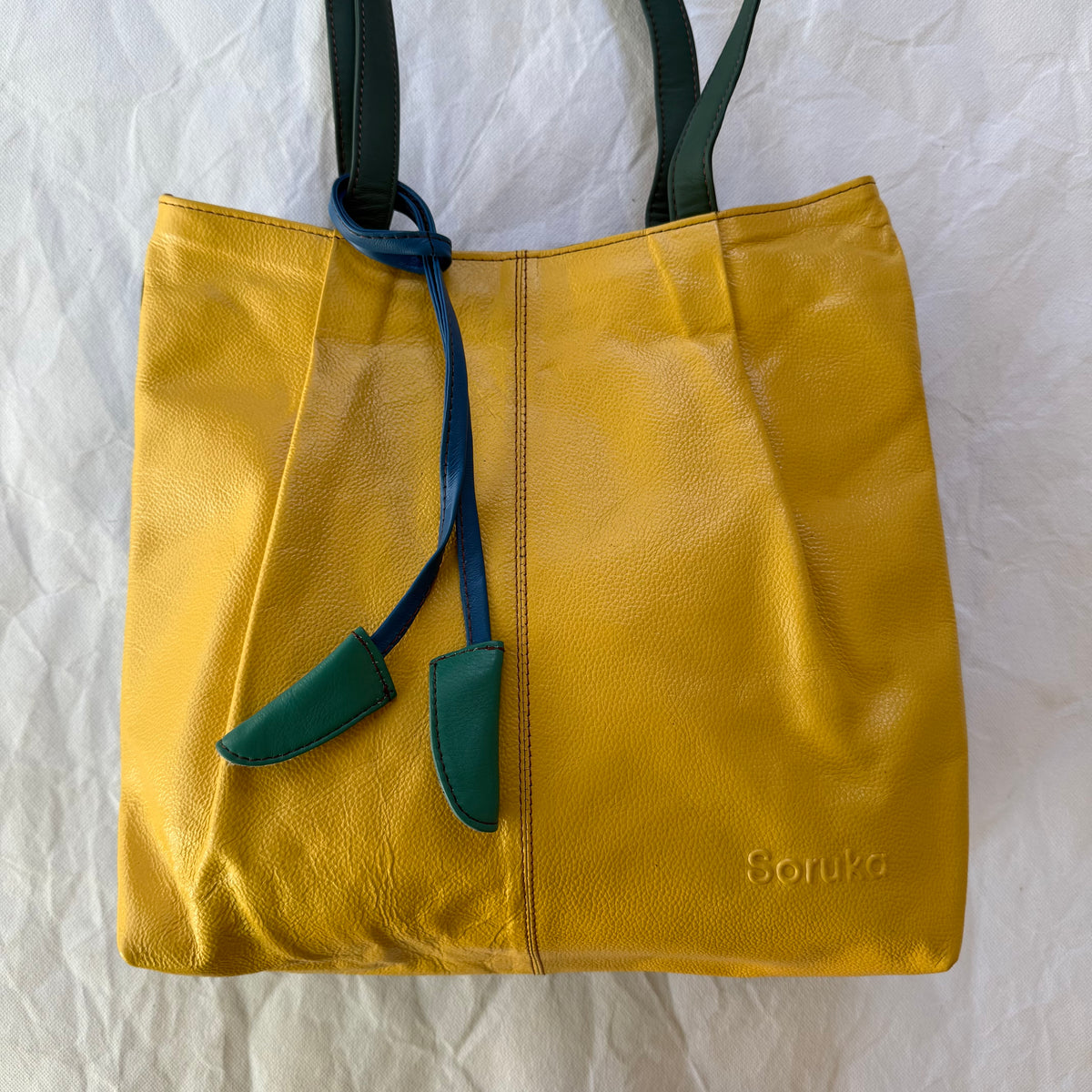 yellow tote with teal tassels and teal straps