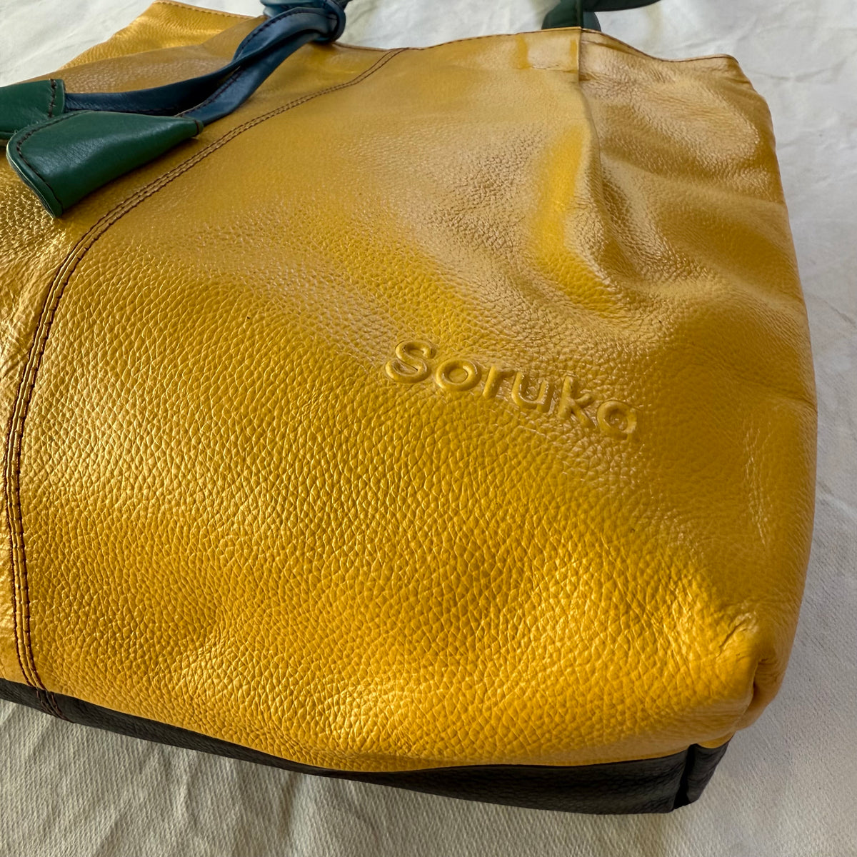 close-up of bottom corner of yellow tote