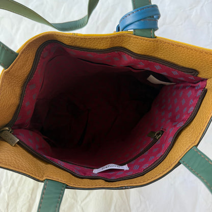 interior view of tote showing maroon patterned lining, slip and zip pockets, and top zipper closure