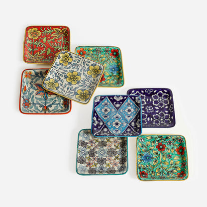 8 colorful square ceramic plates with floral and geometric patterns on a white background