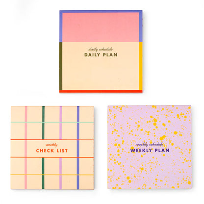 Three colorful small notepads labeled 'Daily Plan', 'Weekly Check List', and 'Weekly Plan' on a white background.