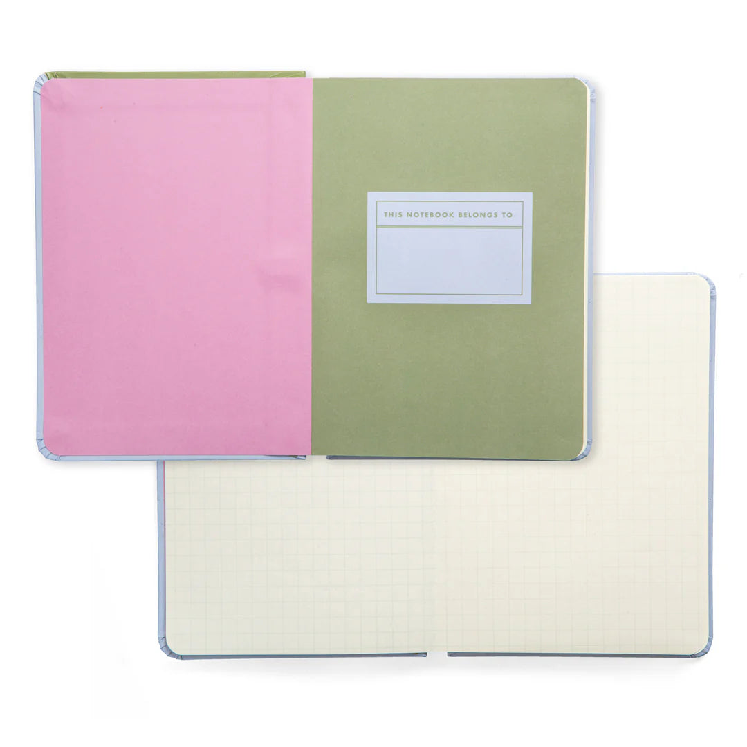 small notebooks open, one to cover page, the other showing grid lined inner pages