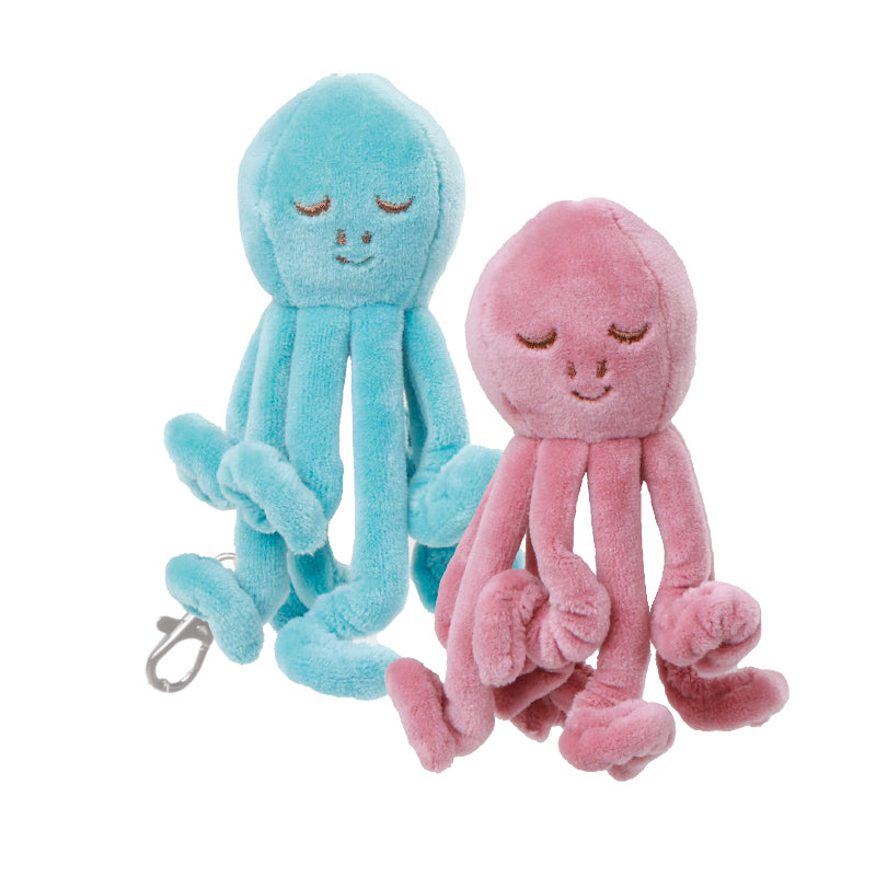 Two plush octopus charms in blue and pink, with closed eyes and smiling faces, designed as bag charms.