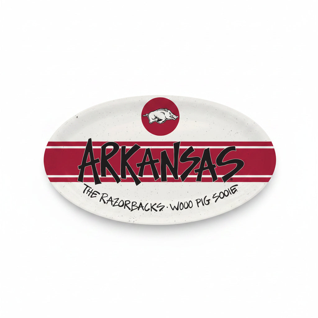 An oval Arkansas Razorbacks themed platter featuring a white background with red horizontal stripes, the word 'ARKANSAS' in black stylized lettering, the Arkansas Razorbacks logo at the top, and the phrase 'THE RAZORBACKS - WOOO PIG SOOIE' at the bottom.