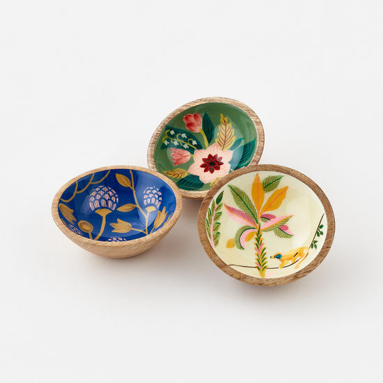 Three enameled mango wood bowls with floral designs in different colors placed side by side.