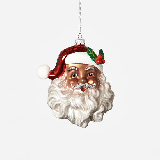 A glass ornament in the shape of a vintage Santa face with a red hat, white beard, and green holly.