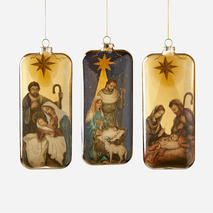 Three glass nativity scene ornaments with a gold background, each with a star at the top shown in a row on a white background