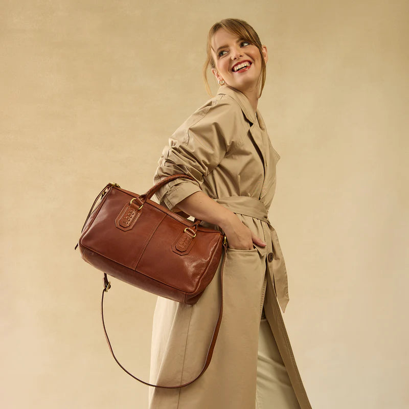 model wearing the expedition satchel in the color pecan ridge on her arm
