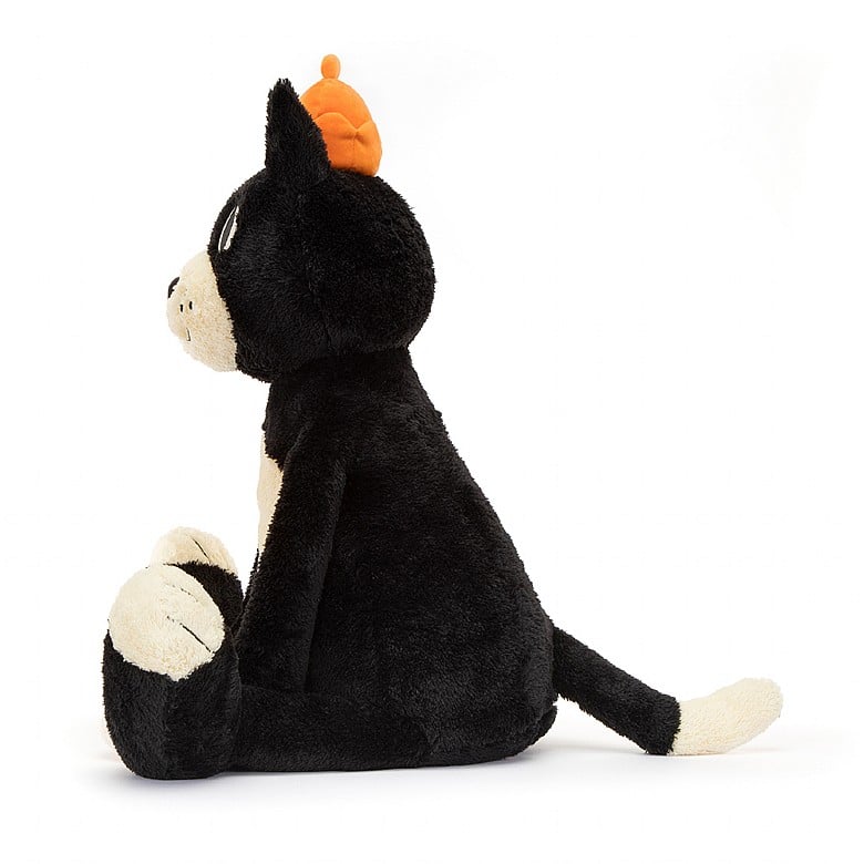 side view of jellycat jack, a black and white stuffed animal wearing an orange crown.