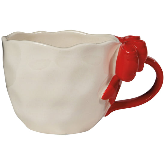 A white ceramic mug with a red sculpted bow tie on the handle