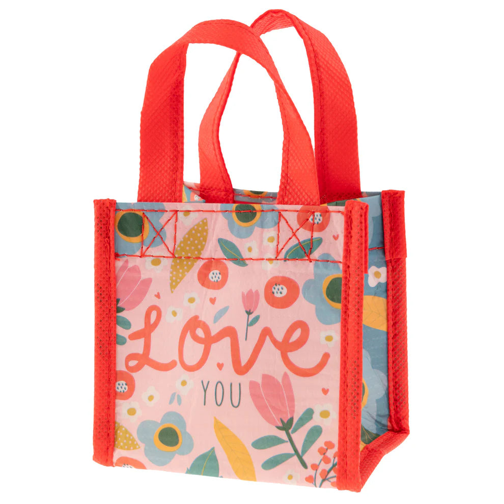 small pale pink gift sack with red handles and trim and colorful floral design and "love you" printed on it
