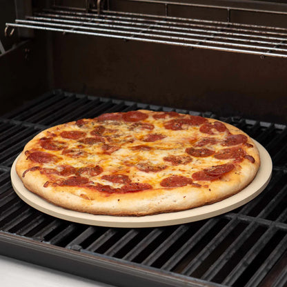 round baking stone in an oven with a pizza on it