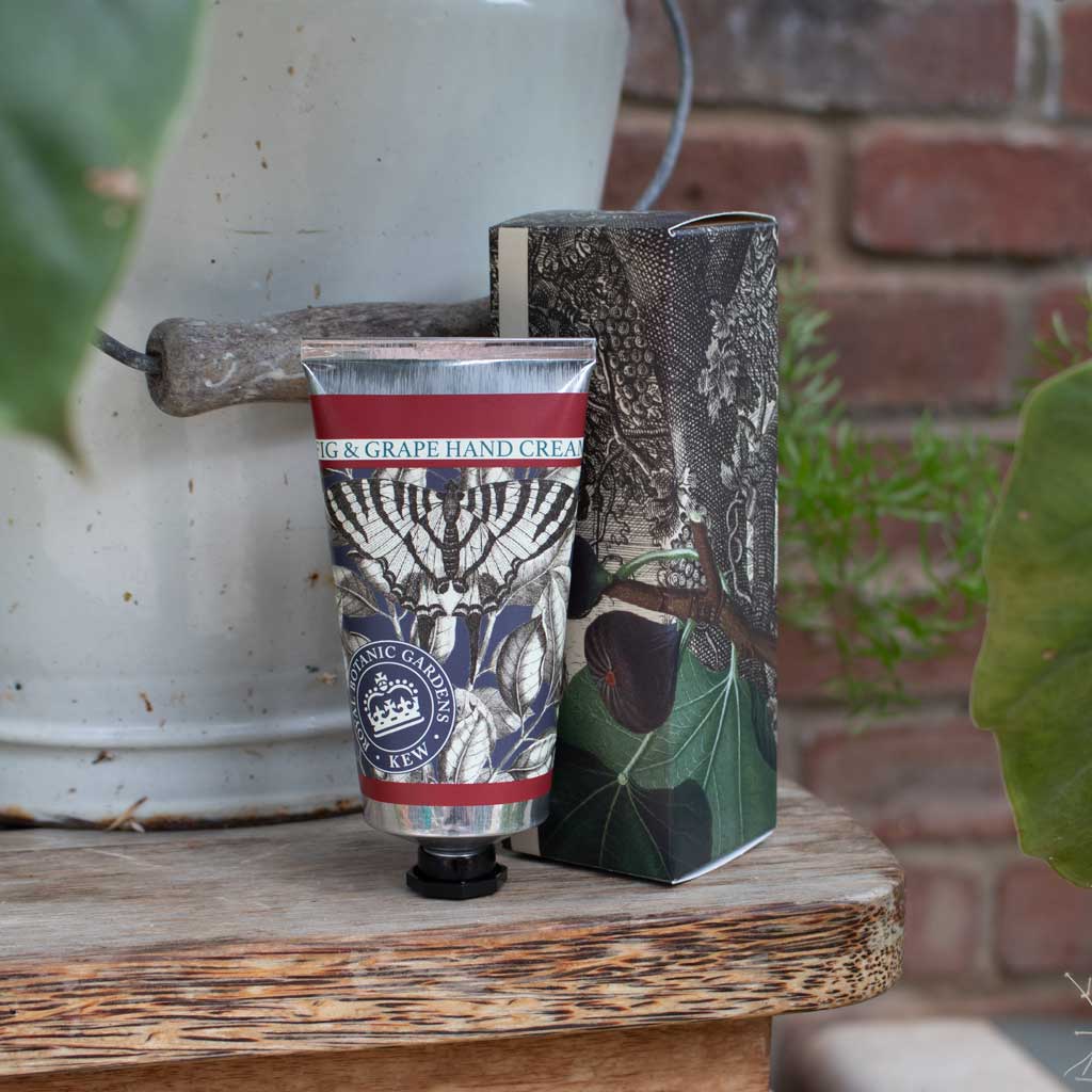 tube of fog and grape hand lotion and its  box in a decorated setting
