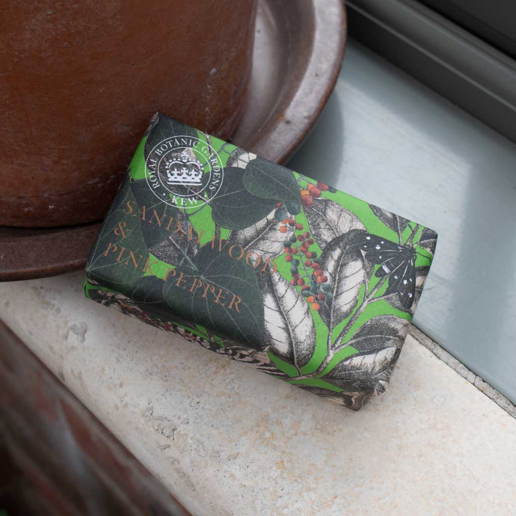 soap bar with wrapper printed with botanical design on a decorated surface