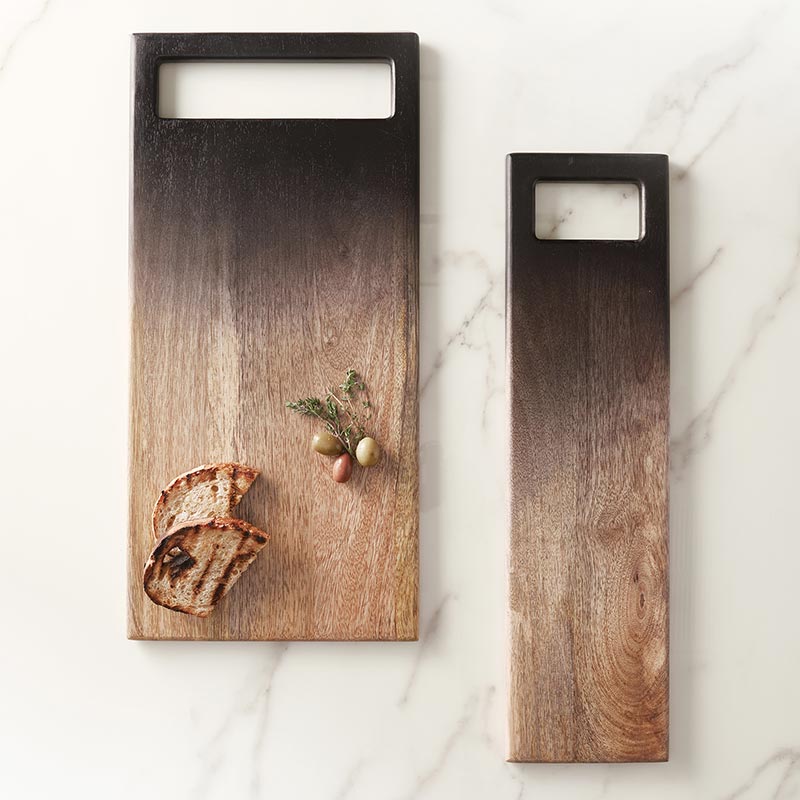 2 styles of ombre serving boards on a marble surface, the large board has breads and olives on it.