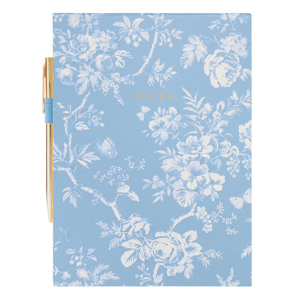 blue and white Floral notebook with a gold pen on a white background