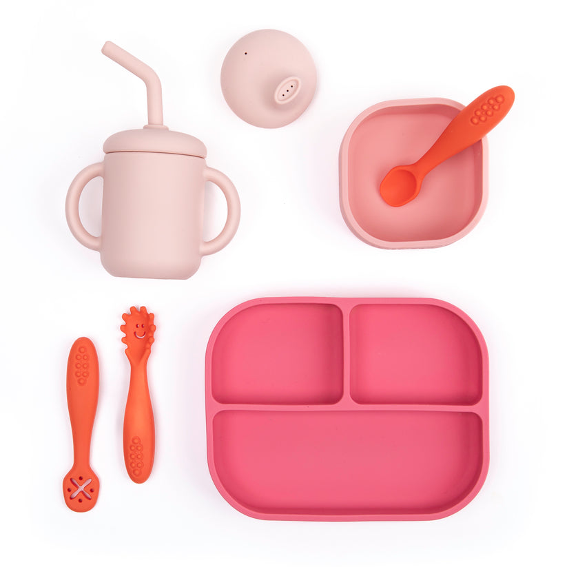 little bites set including a pink plate, light pink bowl, pale pink cup and lids, and orange utensils arranged on a white background.