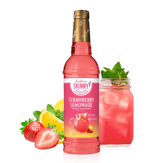 bottle of Strawberry Lemonade skinny syrup set next to a glass of pink lemonade and strawberries and lemon wedges.