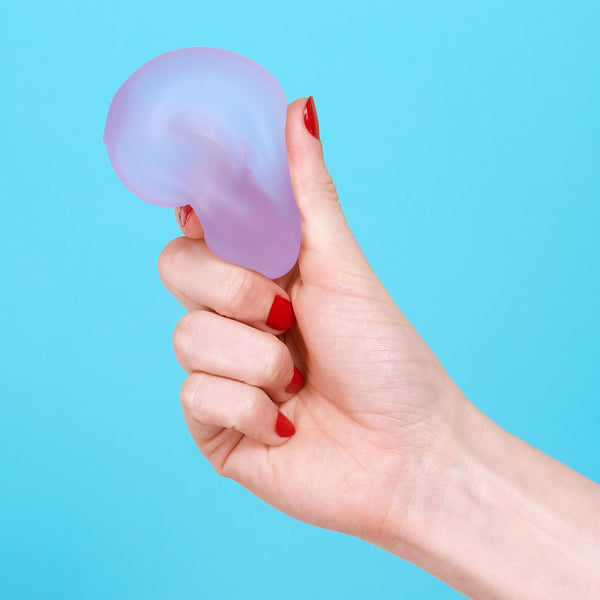Hand holding a purple stress ball loop against a blue background