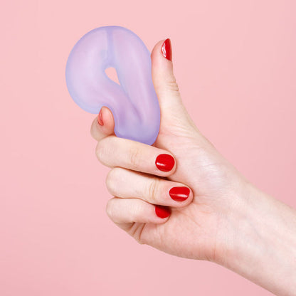 Hand holding a purple stress ball loop against a pink background