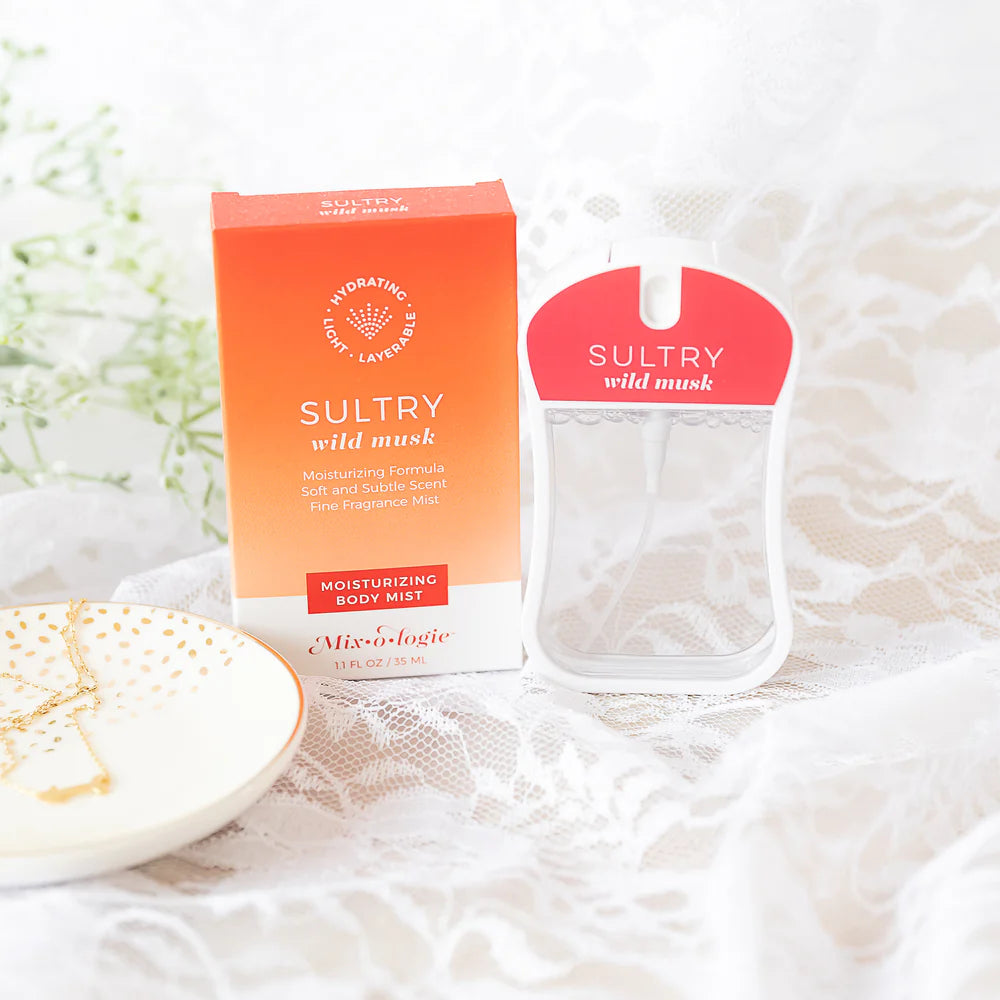 Sultry wild musk body mist and packaging on a textured surface with flowers in the background