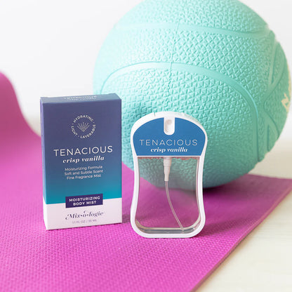 Tenacious crisp vanilla body mist with its box and a teal ball and pink mat in the background