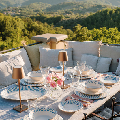 table set with modello dinner ware with a mountain view on the background.