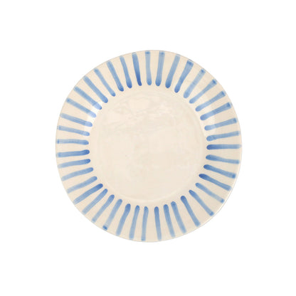 top view of modello salad plate that is white with blue lines radiating around the rim.