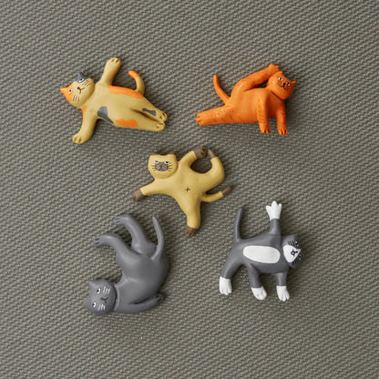 all five cat yoga magnets displayed on a gray surface