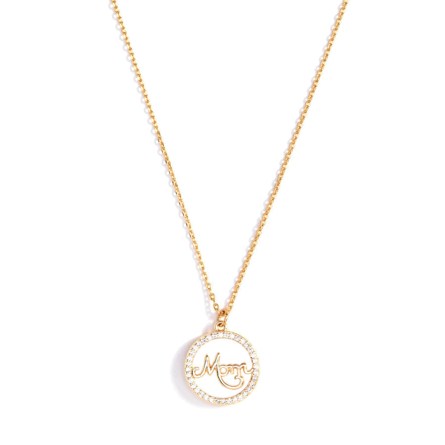 white pendant with pave crystals around the perimeter and "mom" in the center hanging on a gold chain.